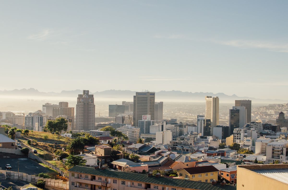 Cape Town buildings under a clear sky with distant mountains.